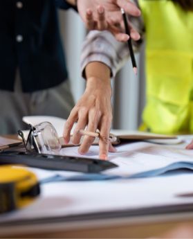 Building plans on table while people discuss